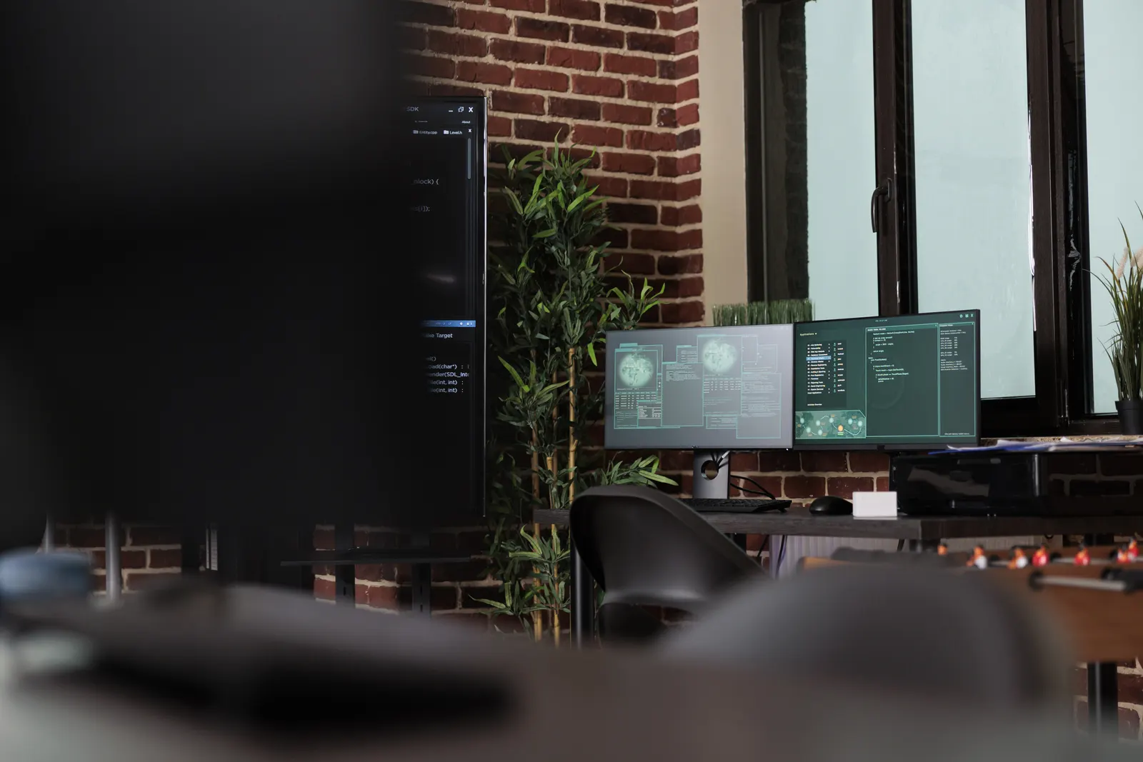 Blick in ein Büro mit Monitoren, auf denen Programmcode läuft