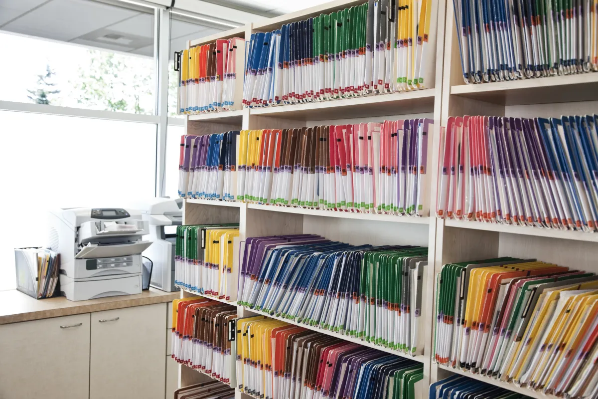 Bunte Aktenordner im Regal — das Papierproblem visualisiert