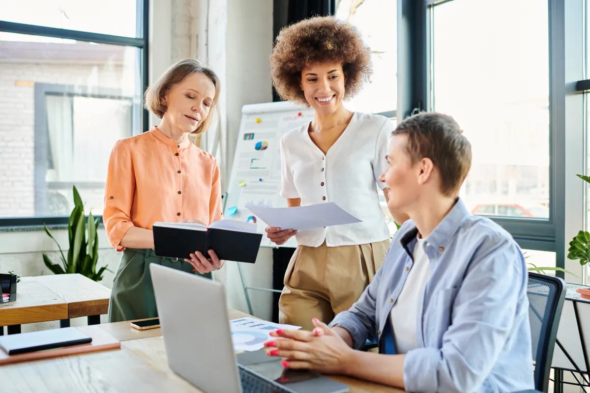 Kolleginnen arbeiten gemeinsam an Dokumenten im modernen Büro