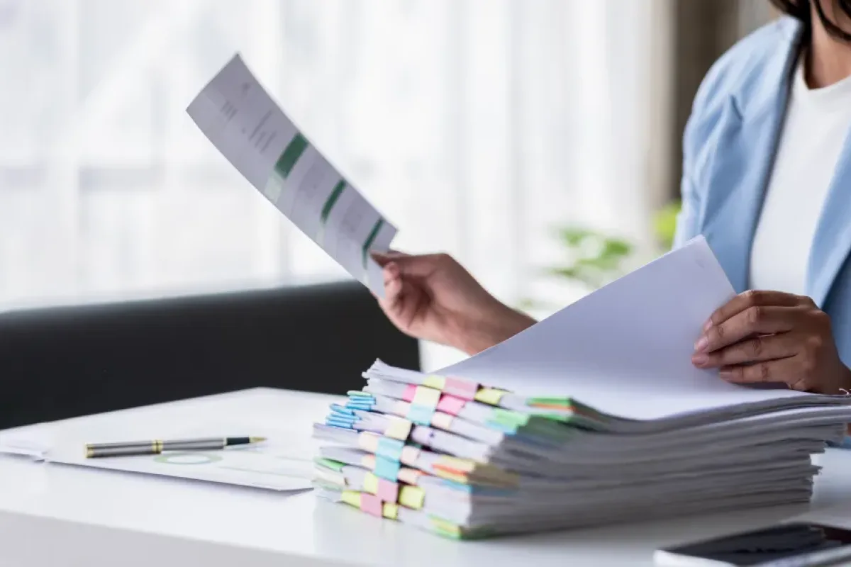 Fachfrau prüft Papierstapel — vor der Digitalisierung