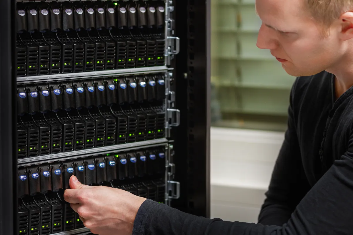 IT-Techniker arbeitet an Server-Racks im Rechenzentrum — professionelle Hardware-Betreuung